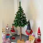 Brad artificial Christmas Deluxe by Sersimo, cu suport pe trunchi de lemn, nins cu conuri, 220cm